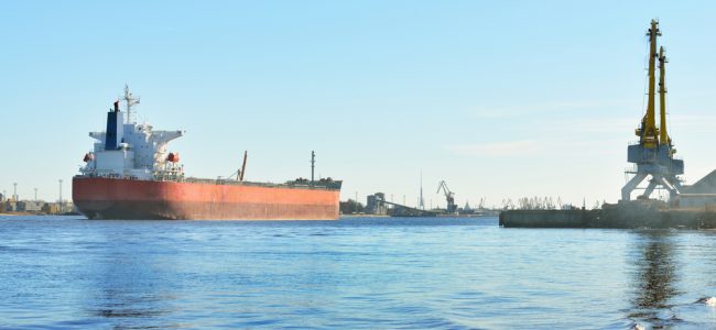 Large cargo ship (Bulk carrier) sailing in a bright sunny day. R